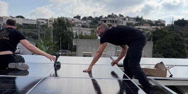 שני טכנאים של Solar Futures מרכיבים פאנלים סולאריים על גג - צילום מפרויקט שביצענו